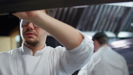 chef reading order slips in restaurant kitchen