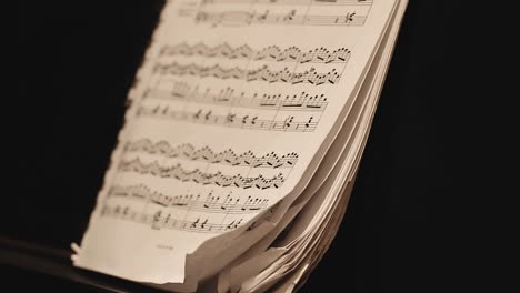 pianist turning the pages of a sheet music while playing the piano.