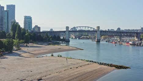 Beautiful-Drone-Aerial-Shot-Flying-Over-Sunset-Beach-Park-Onto-Burrard-Street-Bridge---North-Vancouver-British-Columbia,-Canada