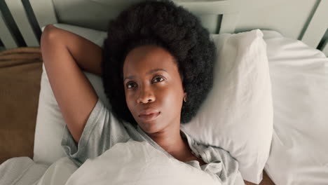 tired black woman wake up in bed frustrated by