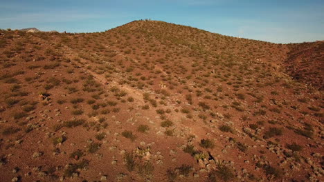 Antena-Drone-De-Un-Fotógrafo-De-Pie-En-La-Cima-De-Una-Colina-Con-Vistas-A-Una-Enorme-Matriz-De-Energía-Solar-Primm-Nevada