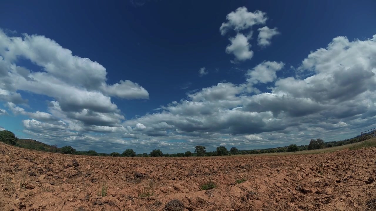 Timelapse di nuvole che scorrono sopra campi agricoli nella regione dell'Alentejo. Terreno arido