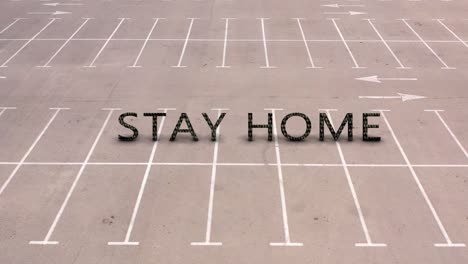 empty parking lot with 'stay home' message