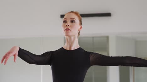 caucasian female ballet dancer practicing ballet during a dance class in a bright studio