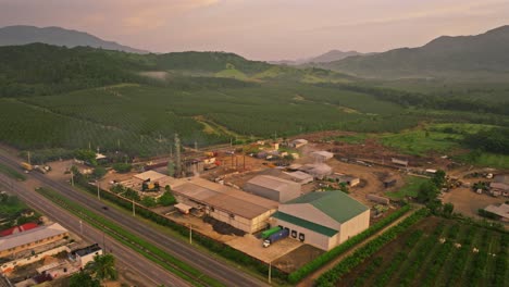 Tráfico-Aéreo-En-Carretera,-Fábrica-Industrial-Y-Plantación-De-Coco-Verde-Al-Amanecer-En-La-Mañana---Villa-Altagracia,-República-Dominicana