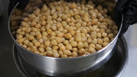 shaking metal bowl full of chickpeas garbanzo beans close up