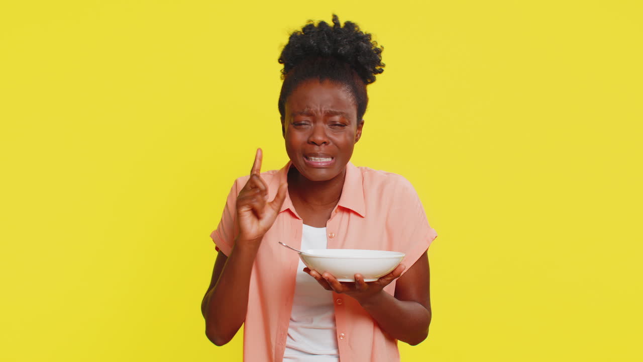 African american woman tasting soup disappointed expression too salty spicy hot holding spoon bowl