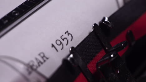 year 1953, typing on white paper in vintage typewriter, close up