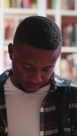 college learners scan books standing among bookshelves. young man with female companion learns book preparing to science project writing. library visitors