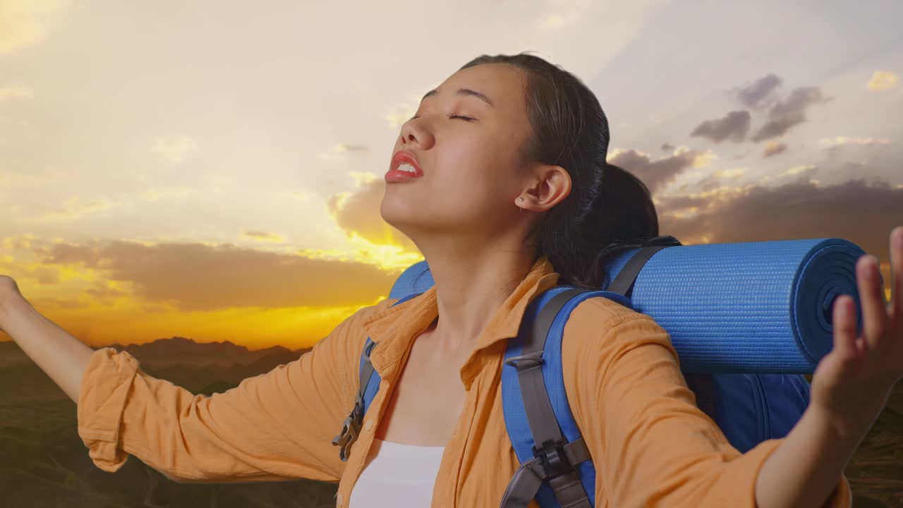해가 지는 산에서 하이킹하는 여자
