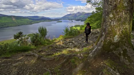 woman female taking a photograph on a mobile phone view across derwentwater in the english lake district looking towards the town of keswick with skiddaw behind