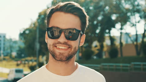 hombre sonriente con gafas de sol al aire libre