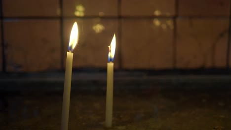 two candles burning in a church