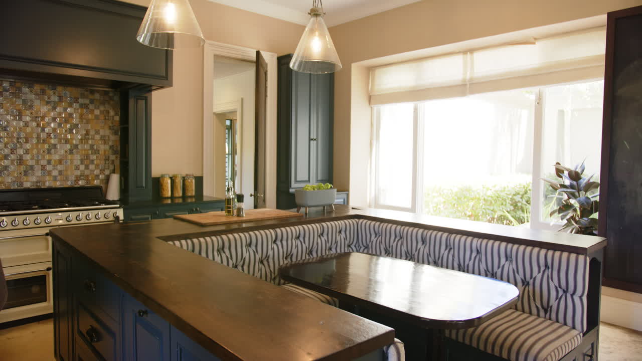 Modern kitchen with built-in dining nook and large windows, creating cozy atmosphere, copy space