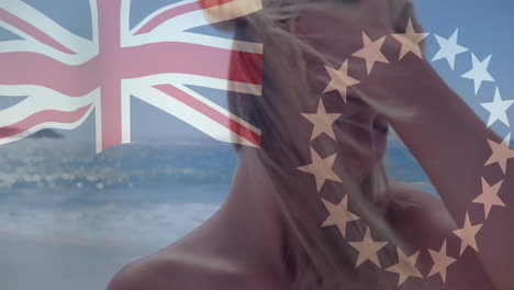 at beach, animation of union jack and eu flag overlaying person with windblown hair