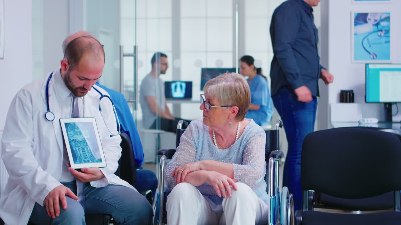 Doctor explaining diagnosis to elderly woman in wheelchair