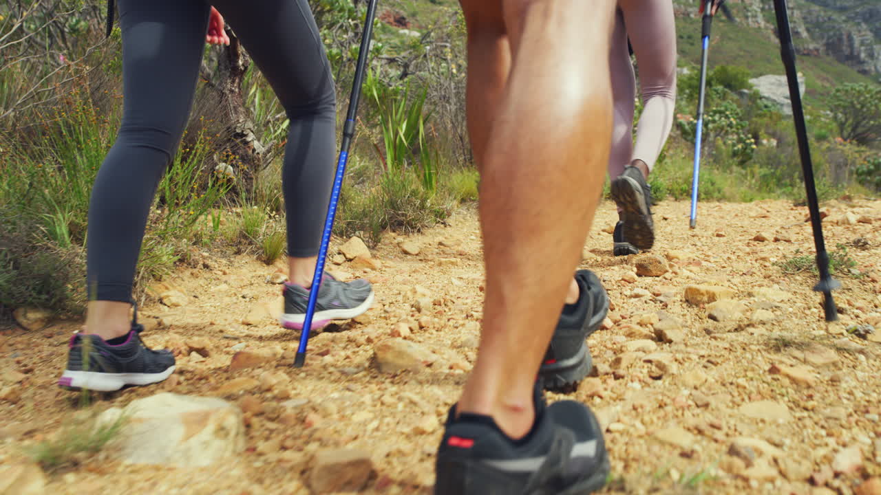 vista trasera de los excursionistas caminando por una montaña rocosa