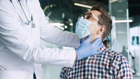 Close-up-view-of-male-patient-in-glasses-wearing-medical-mask-sitting-in-medical-consultation-at-doctor-appointment