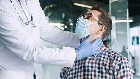 vista de primer plano de un paciente masculino con anteojos que usa una máscara médica sentado en una consulta médica en una cita con el médico