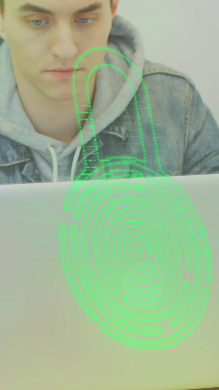 Animation of fingerprint in padlock over caucasian man working on laptop with coffee cup on table