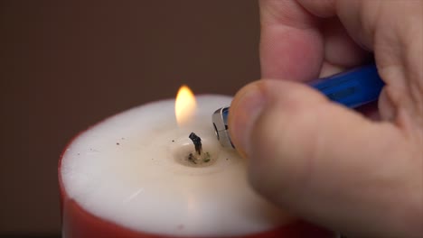 mano masculina encendiendo velas cuidadosamente con una llama más ligera