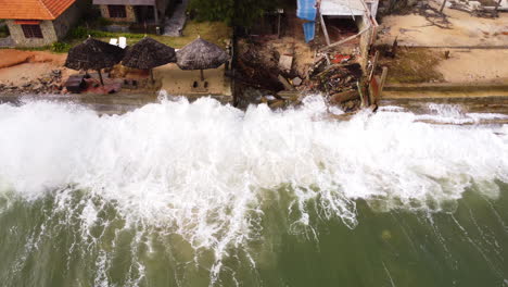 Drone-top-down-shot-of-destroyed-coastline-after-crashing-waves-of-ocean-at-night---Environmental-catastrophe-flooding-Vietnam-Island