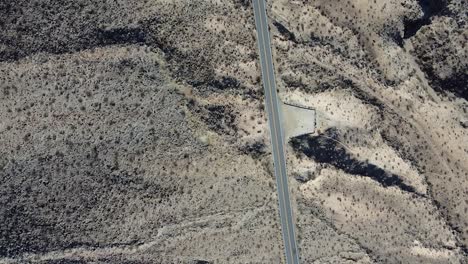 Carretera-Vacía-Con-Parada-De-Hormigón-En-El-Desierto-De-California,-Toma-Aérea-De-Arriba-Hacia-Abajo