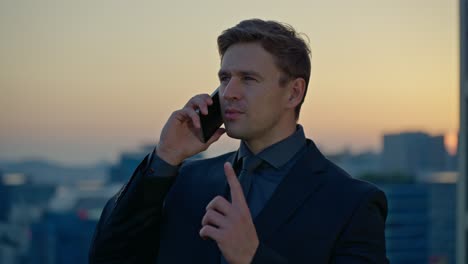 a caucasian businessman leader encourages a partner during a phone conversation, making a number 1 gesture to promise success while on a rooftop in seoul