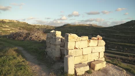 shelter made from rocks and built upon hill with view to mediterranean sea and greenery