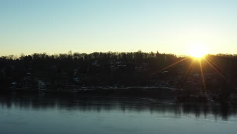 Intense-sunrise-drone-flight-over-frigid-winter-lake-in-the-mountains