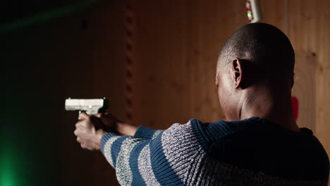 man at firing range location loading pistol with ammunition, close up