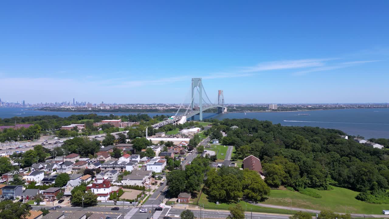 Stunning aerial view of Staten Island and the Verrazzano-Narrows Bridge with a clear skyline, waterfront, and residential neighborhoods under a bright blue sky