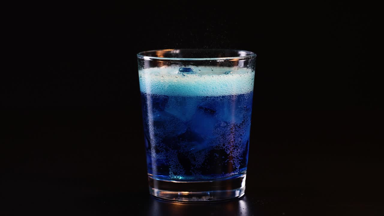 유리잔에 얼음이 들어있는 걱거리는 파란색 음료