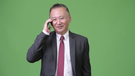 성숙한 일본 사업가 전화를 사용
