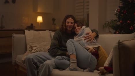 couple cozying up on the sofa during christmas