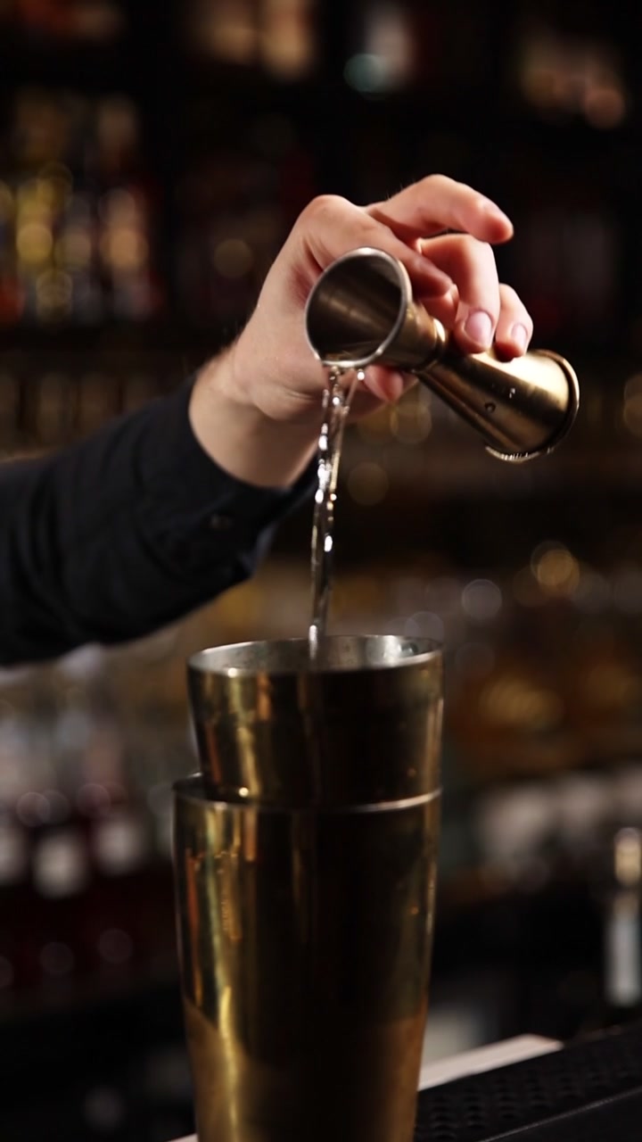 Bartender Derramando Líquido Medido em uma Coqueteleira