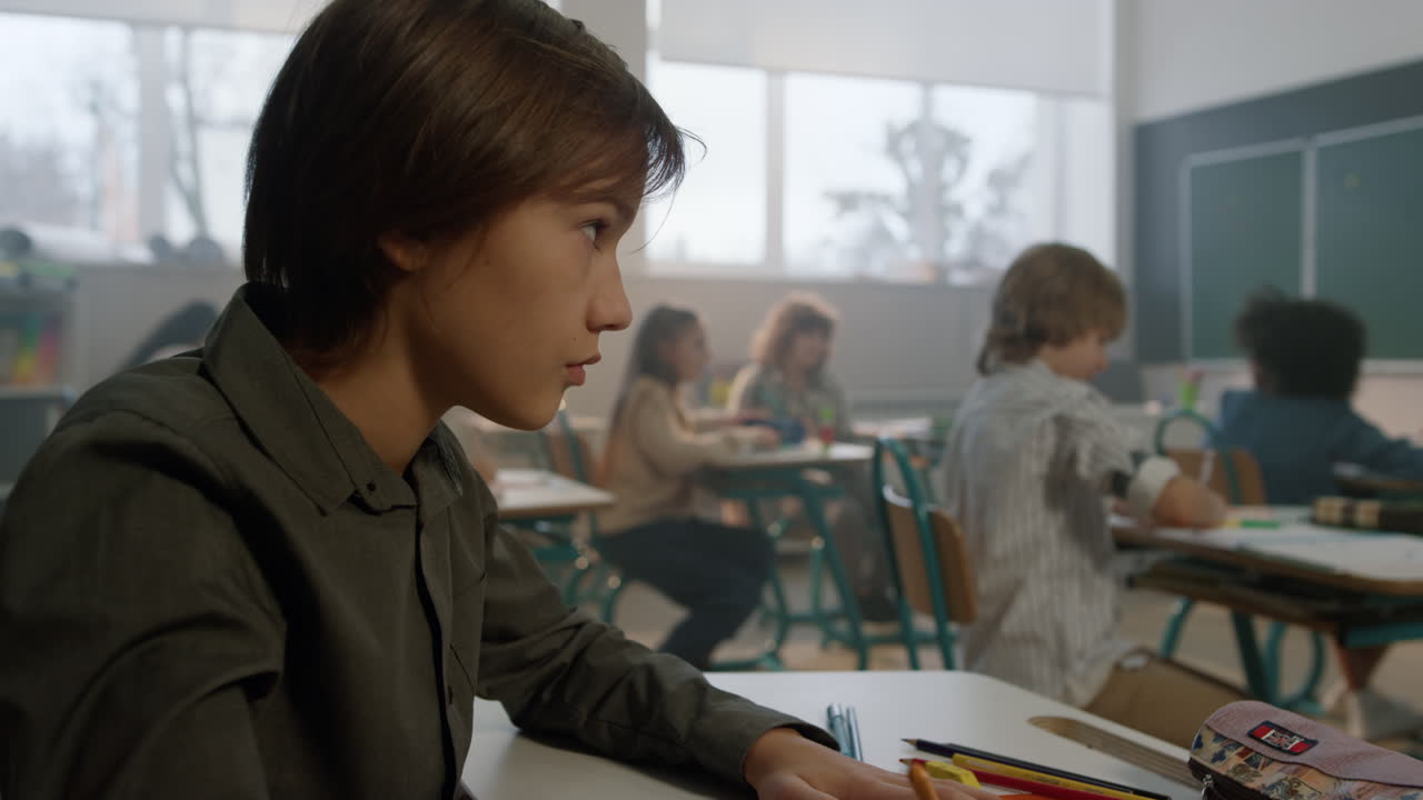 niño aprendiendo en el aula. estudiante inteligente mirando la pizarra durante la lección