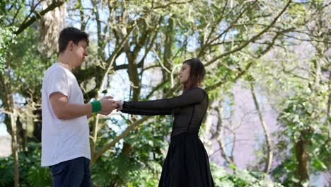 una pareja en el parque tomándose de la mano.