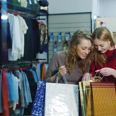 satisfied customers look into their shopping bags at the clothing store