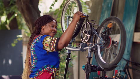 Mujer-Sonriente-Comprobando-Componentes-De-Bicicleta.