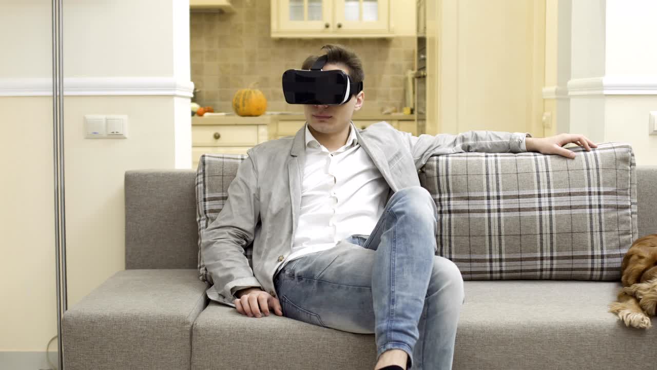 un joven usa gafas de realidad virtual en casa.