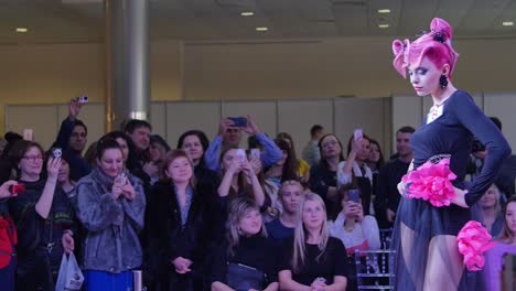 desfile de moda con cabello rosa y maquillaje creativo