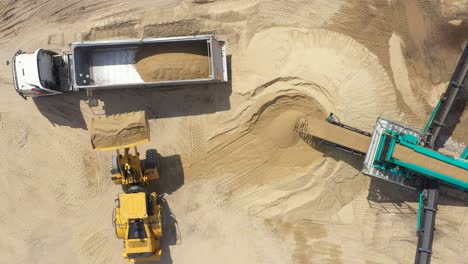 Aerial-view-loading-bulldozer-in-open-air-quarry