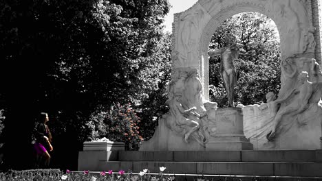 Hermosa-Mujer-Asiática-Vestida-De-Purle-Visitando-El-Monumento-A-Johann-Strauss-En-Color-Blanco-Y-Negro,-Cámara-Lenta,-Toma-Amplia