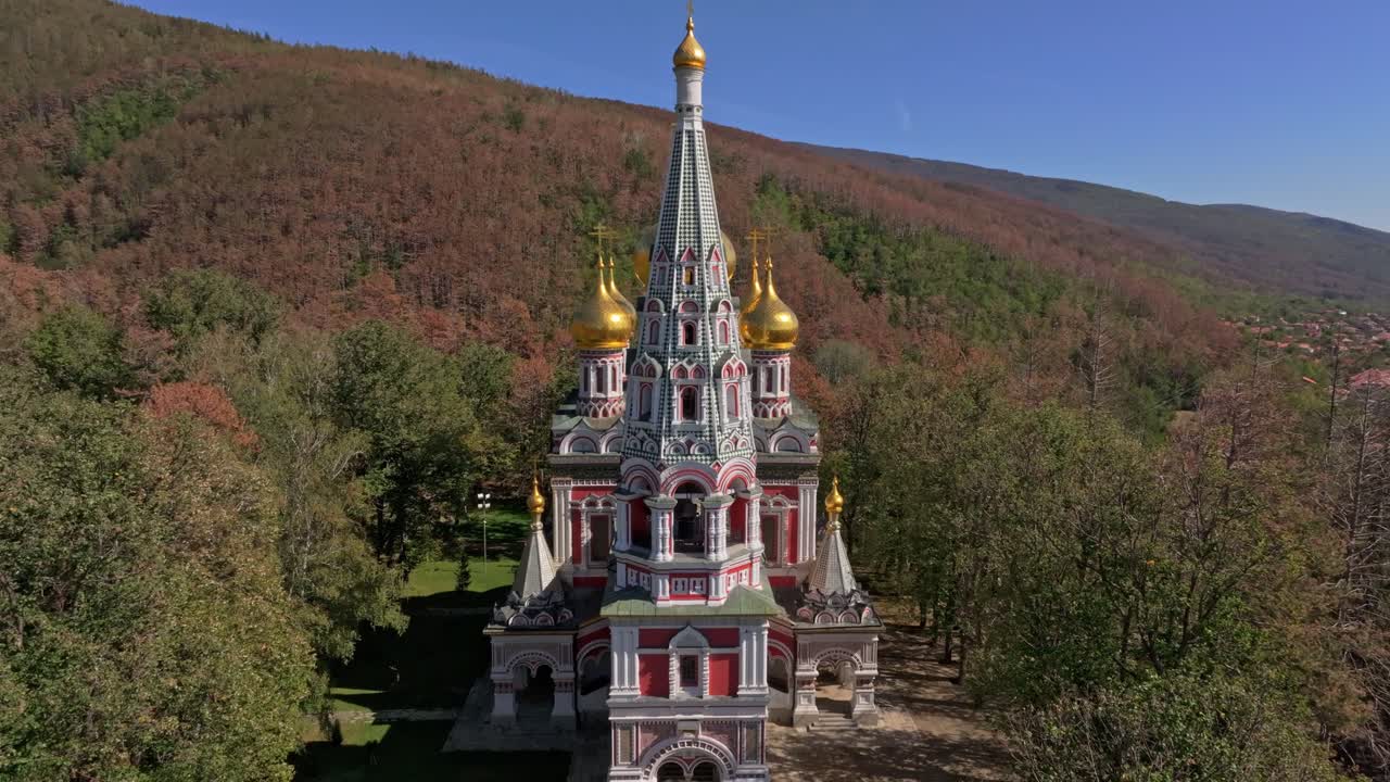 Shipka-kupler rager gjennom flammende høsttretopper, Bulgaria