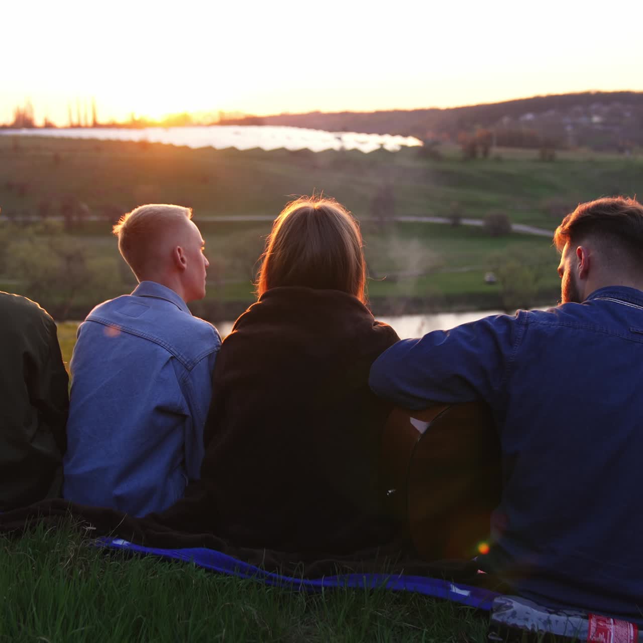 Friends sitting on nature sunset. Lifestyle outdoor people friendship
