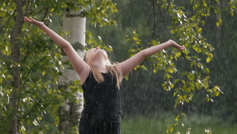 joven rubia en la lluvia de verano mirando hacia el cielo abrazando a dios y milagros, cámara lenta