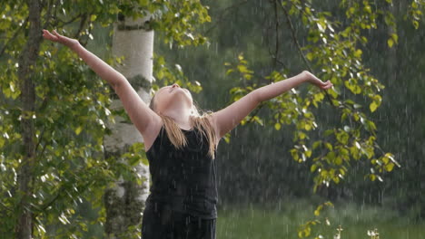 young blonde girl in summer rain looking up at sky embracing god and miracles, slow motion