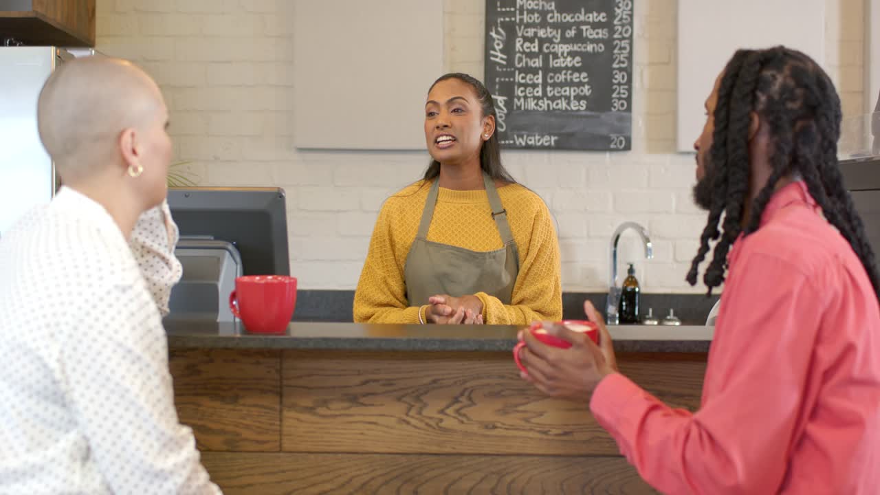 Customer question leading Indian barista explaining specialty drinks behind counter in coffee shop