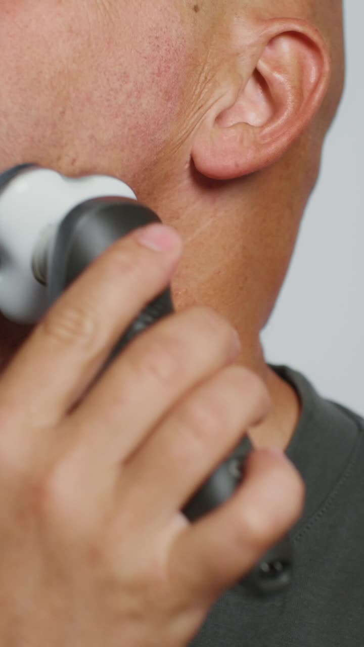 hombre afeitando su cara con una navaja eléctrica